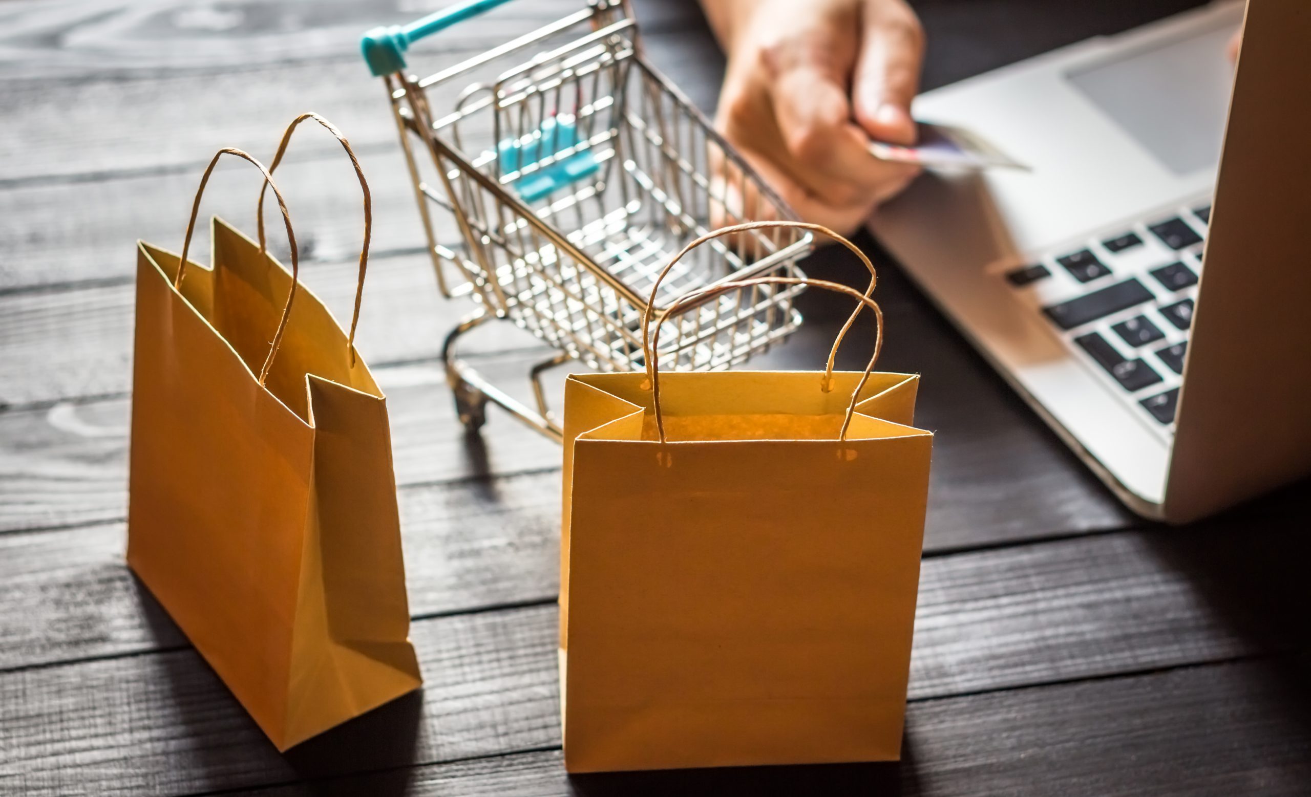 online-shopping-concept-young-men-holding-credit-card-using-laptop-on-wooden-backdrop-black-friday_t20_pxO6YW-scaled