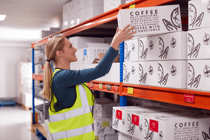 female-worker-inside-busy-warehouse-putting-box-on